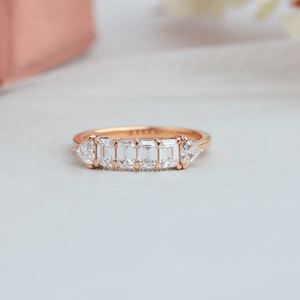 Emerald cut lab grown diamond half eternity wedding band with trillion cut side stones in solid yellow gold