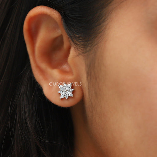 Marquise Cut Cluster Stud Earrings worn on an ear, showcasing the sparkling floral design of lab-grown diamonds against the skin.