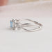 14k white gold infinity shaped curved shank of blue radiant diamond ring
