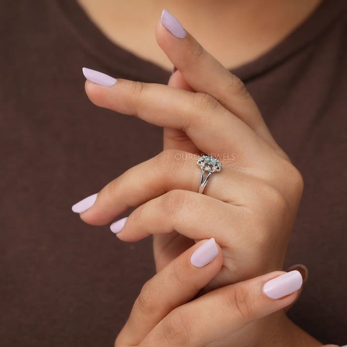 In finger side view of oval shaped diamond ring, this floral engagement ring made of 14k white gold.