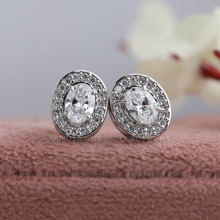 Oval brilliant cut lab created diamond stud earrings with claw prongs and sparkling halo of round diamonds