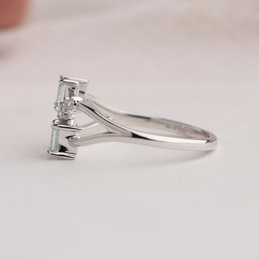 side view of green princess-cut lab diamond dainty wedding ring on grey fabric